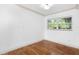 Cozy bedroom with hardwood floors, neutral walls, and a bright window at 611 N Garfield Ave, Deland, FL 32724