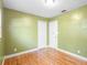 This bedroom features bright green walls, bright windows, hardwood floors, and closet for ample storage at 611 N Garfield Ave, Deland, FL 32724