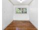 Small bedroom with hardwood floors, neutral walls, and a bright window at 611 N Garfield Ave, Deland, FL 32724