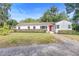 Charming single-story home with a well-maintained lawn and a vibrant red front door at 611 N Garfield Ave, Deland, FL 32724