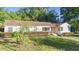 A cozy single-story house, featuring a well-manicured lawn and a charming red front door at 611 N Garfield Ave, Deland, FL 32724