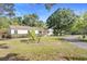 Charming single-story house featuring a well-maintained lawn and a gravel driveway at 611 N Garfield Ave, Deland, FL 32724