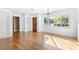 Bright living room with hardwood floors, white trim, and a traditional wooden front door at 611 N Garfield Ave, Deland, FL 32724