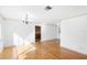 Spacious living room boasts wood floors, white walls, and an elegant chandelier at 611 N Garfield Ave, Deland, FL 32724
