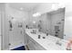 Bright bathroom with double vanity, large mirror, and glass-enclosed shower at 614 Becklow St, Debary, FL 32713