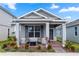 Charming single-story home with a well-manicured lawn and inviting front porch with chairs and landscaping at 614 Becklow St, Debary, FL 32713