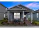 Charming single-story home with a well-manicured lawn and inviting front porch with chairs and landscaping at 614 Becklow St, Debary, FL 32713