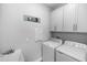 Efficient laundry room with a sink, cabinetry, washer, and dryer setup for convenient laundry tasks at 614 Becklow St, Debary, FL 32713