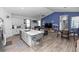 Open-concept living space with kitchen island, dining area, and living room with vaulted ceiling and blue accent wall at 614 Becklow St, Debary, FL 32713