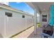 Enclosed patio area showcasing a cozy outdoor space with a white fence, brick floor and shade at 614 Becklow St, Debary, FL 32713