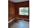 Small bedroom with wood paneling and a window providing natural light and backyard views at 615 Weber Ave, Daytona Beach, FL 32114