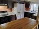 Functional kitchen with a refrigerator, stove, countertop, and dark wood cabinets at 615 Weber Ave, Daytona Beach, FL 32114