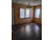 Cozy living room with a chandelier, hardwood floors, and natural light from two large windows at 615 Weber Ave, Daytona Beach, FL 32114