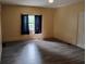 A spacious living room features wood-look flooring, a ceiling fan, and a window for natural light at 615 Weber Ave, Daytona Beach, FL 32114