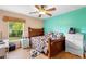 Bedroom with wood floors, neutral paint and window overlooking trees at 685 N Firwood Dr, Deltona, FL 32725