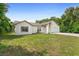 Single story home with green grass, side view, and a large tree in the back at 685 N Firwood Dr, Deltona, FL 32725