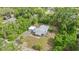 An aerial view of a well-maintained single-story home with a detached garage, and lush greenery at 710 W May St, Deland, FL 32720