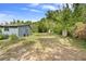 Open backyard with a small shed and mature vegetation at 710 W May St, Deland, FL 32720