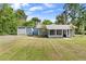 Charming single-story home with a screened porch and detached garage surrounded by a lush green lawn at 710 W May St, Deland, FL 32720