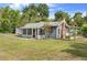 Angle view of a single-story home with screened in front porch, brick chimney, and detached garage at 710 W May St, Deland, FL 32720