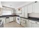 White kitchen cabinets, tile flooring, and appliances at 710 W May St, Deland, FL 32720