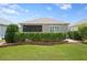 Well-manicured backyard with lush green lawn, privacy hedges, and exterior view of screened in porch at 7732 Sw 86Th Ct, Ocala, FL 34481