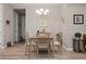 A formal dining room features a modern chandelier and a wooden table set for four at 7732 Sw 86Th Ct, Ocala, FL 34481