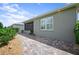 Exterior view of home featuring a paver walkway and mature landscaping leading to screened lanai at 7732 Sw 86Th Ct, Ocala, FL 34481