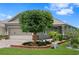 Charming home exterior featuring a manicured lawn, brick-lined flower bed, and two-car garage at 7732 Sw 86Th Ct, Ocala, FL 34481