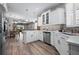 Open kitchen design with white cabinets, stainless steel appliances, and a view of the living area at 7732 Sw 86Th Ct, Ocala, FL 34481