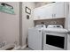 Functional laundry area featuring modern washer and dryer, and upper cabinets for ample storage at 7732 Sw 86Th Ct, Ocala, FL 34481