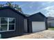 Modern dark gray home with a white garage door and trimmed window at 822 W 24Th St, Sanford, FL 32771
