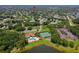 Aerial view showcasing community clubhouse, pool, tennis courts, lake and the surrounding mature landscaping at 955 Grayling Ct # B, Port Orange, FL 32127