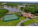 An aerial shot displays the community's serene lake, tennis courts, and clubhouse pool area at 955 Grayling Ct # B, Port Orange, FL 32127