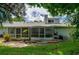 Rear exterior view of the house showing a screened patio, landscaping, and backyard at 955 Grayling Ct # B, Port Orange, FL 32127