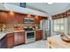Well-lit kitchen featuring stainless steel appliances and attractive cherry wood cabinetry for a modern cooking experience at 955 Grayling Ct # B, Port Orange, FL 32127