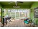 Relaxing sunroom/patio with ample seating, fan, and an 'Our Happy Place' sign. Perfect for indoor/outdoor living at 955 Grayling Ct # B, Port Orange, FL 32127