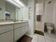 Bright bathroom featuring a large mirror, vanity with cabinets, and a tiled walk-in shower at 955 Thelma St, Orange City, FL 32763