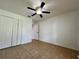 Neutral bedroom featuring tile floors, a ceiling fan, and a double-door closet at 955 Thelma St, Orange City, FL 32763