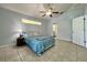 Bedroom features a ceiling fan, window, neutral paint, and access to an ensuite bathroom at 955 Thelma St, Orange City, FL 32763