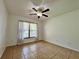 Bedroom features neutral paint, tile floors, and window overlooking the yard at 955 Thelma St, Orange City, FL 32763