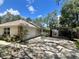 Features a spacious driveway with a carport and garage, surrounded by well-kept landscaping at 955 Thelma St, Orange City, FL 32763
