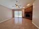 Spacious living room with tile floors, a ceiling fan, and a traditional brick fireplace at 955 Thelma St, Orange City, FL 32763