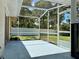 Screened-in patio with light blue floors, a white fence, and a view of the lush backyard at 955 Thelma St, Orange City, FL 32763