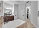 Bathroom featuring soaking tub, walk-in closet, and separate vanities at 101 Briargate Look, Ormond Beach, FL 32174