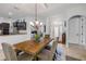 Dining room with rustic wooden table and chairs, featuring an elegant chandelier and front door view at 101 Briargate Look, Ormond Beach, FL 32174