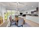 Dining area with a wooden table, bench seating, and a view into the living room and kitchen at 101 Briargate Look, Ormond Beach, FL 32174