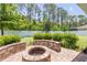Outdoor fire pit with brick surround and lush landscaping at 101 Briargate Look, Ormond Beach, FL 32174