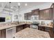 Modern kitchen featuring stainless steel appliances, granite countertops, dark cabinets, and recessed lighting at 101 Briargate Look, Ormond Beach, FL 32174