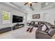 Cozy living room with a large TV, comfortable seating, a plush rug, and abundant natural light from the windows at 101 Briargate Look, Ormond Beach, FL 32174